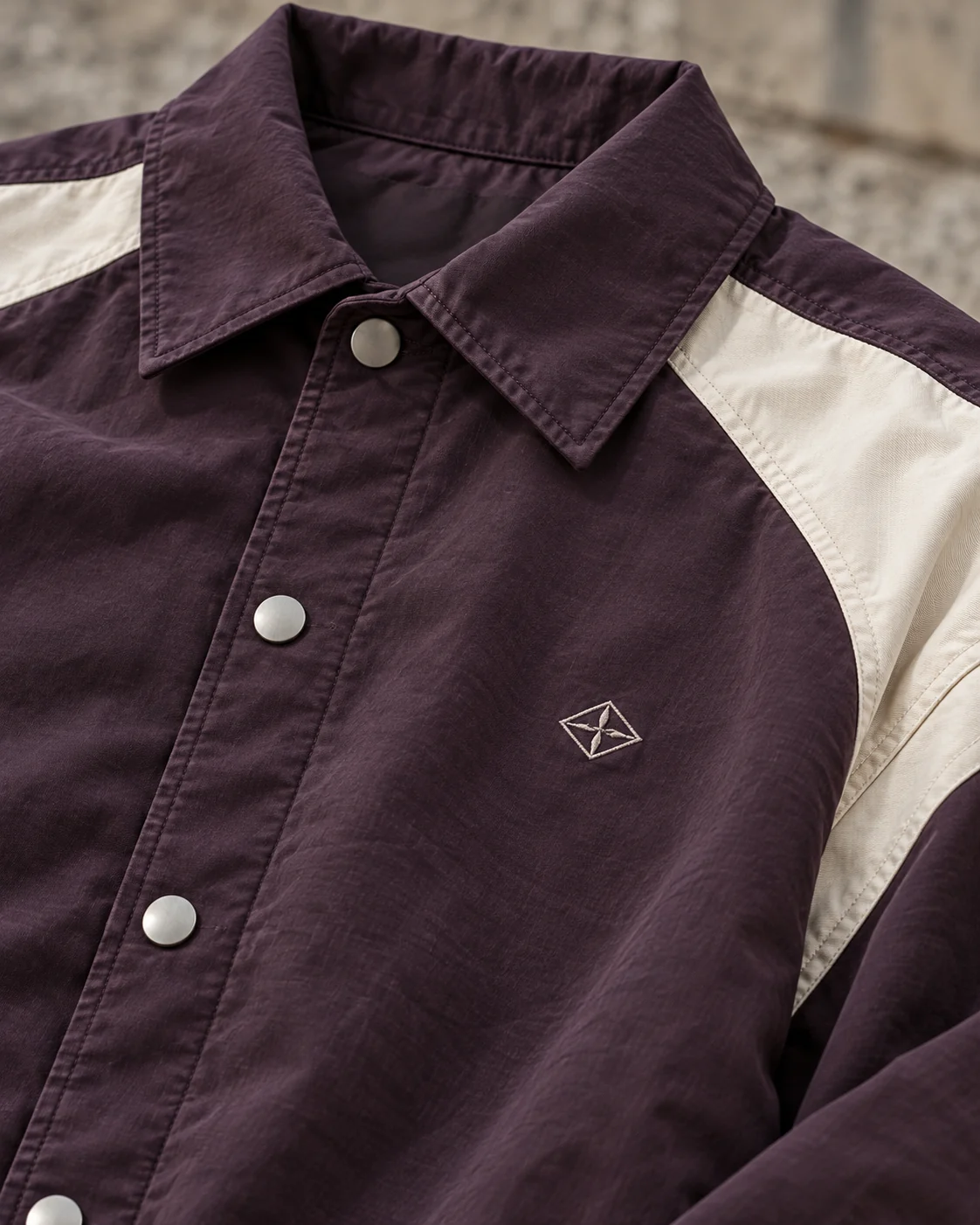 Close-up of fabric and signature construction — Coach Jacket in washed aubergine / bone, AI-generated design concept
