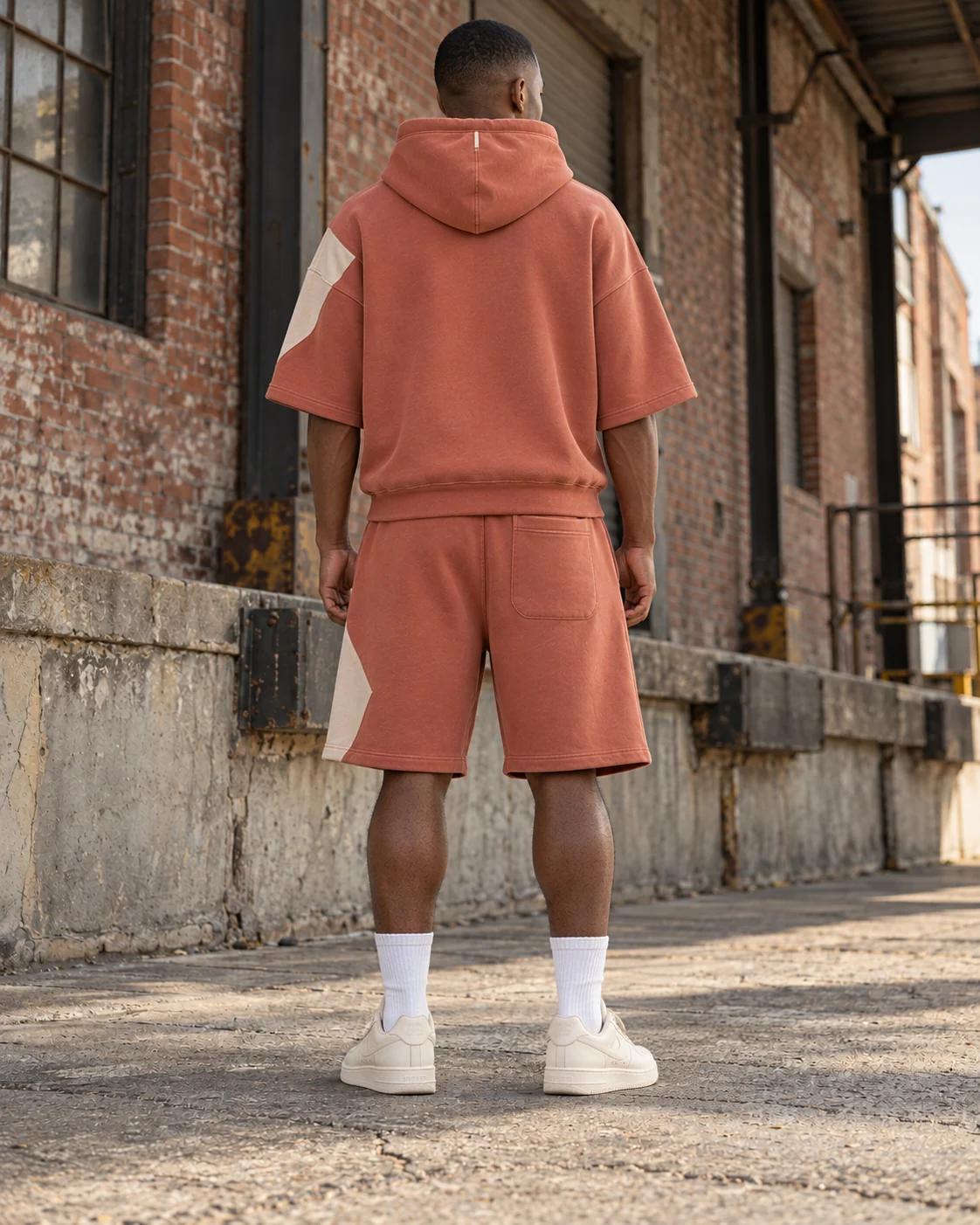 Back view of the same coordinated set — Hoodie & Shorts Set in faded clay / bone, AI-generated design concept