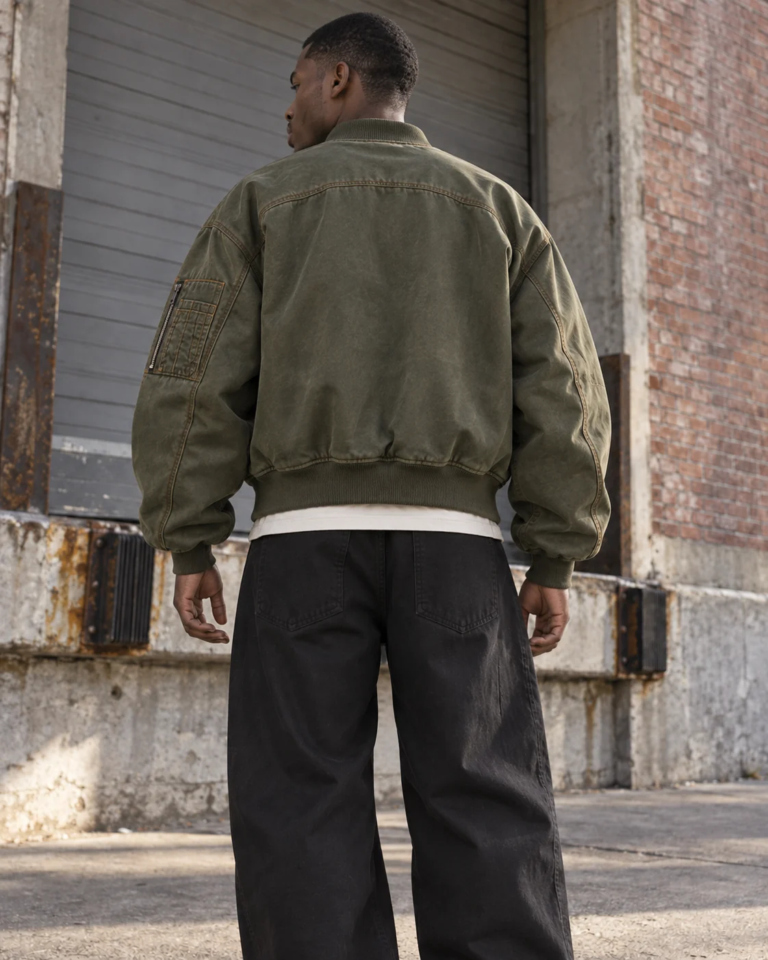 Distinct back design on the same model — Oversized Bomber Jacket in washed olive / rust, AI-generated design concept