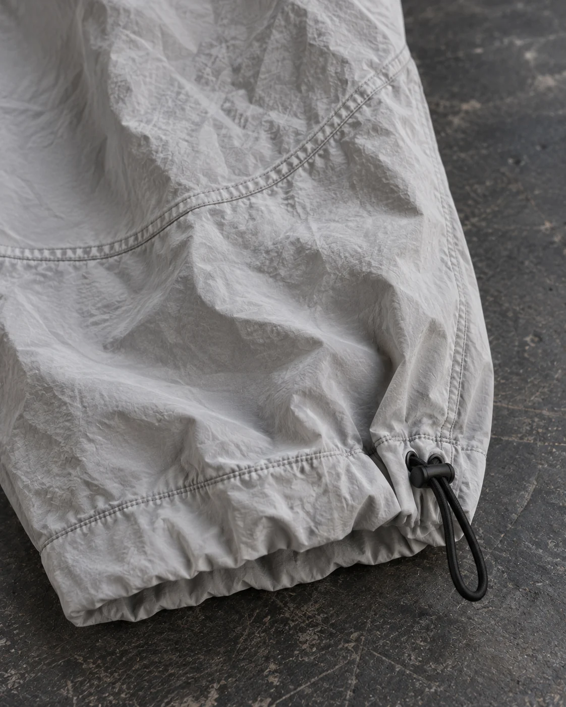 Close-up of fabric and signature construction — Parachute Pants in stone grey / charcoal, AI-generated design concept